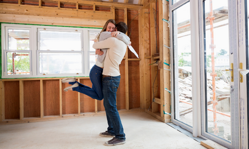 Couple in newly built house hugging